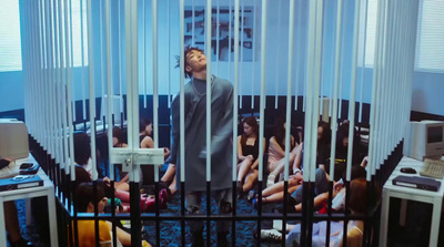 a man standing in front of a group of people behind bars