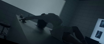 a man leaning over a counter in a dark room