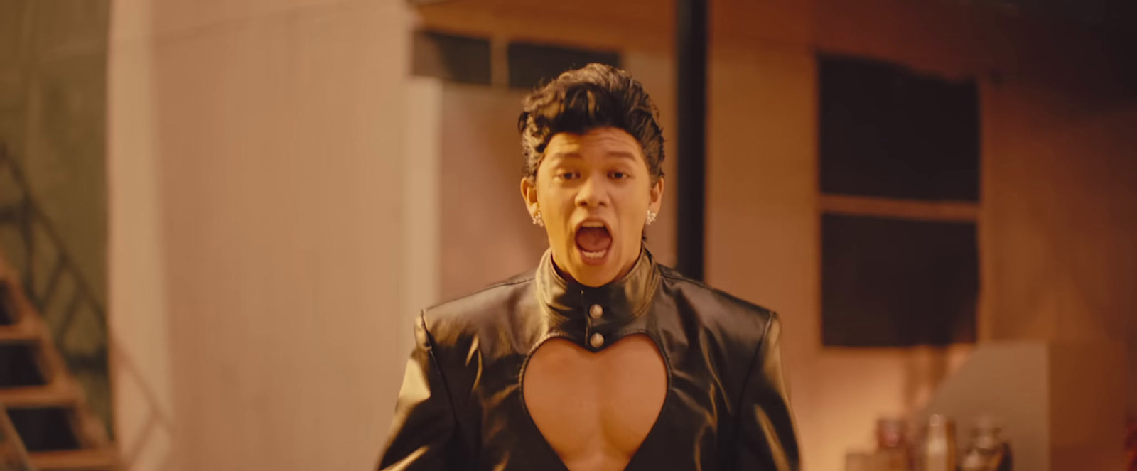 a man in a leather outfit with his mouth open