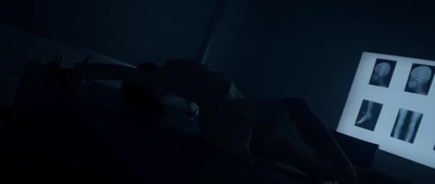 a person laying on a bed in a dark room