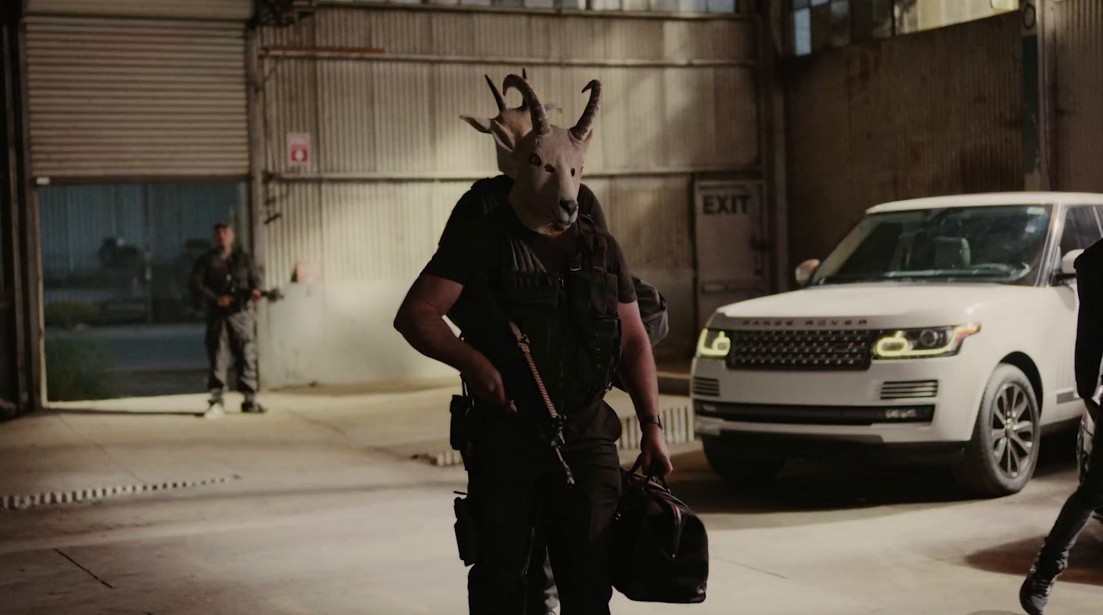 a man wearing a goat mask and carrying a bag