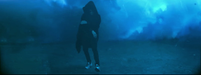 a person standing in the water with a hood on