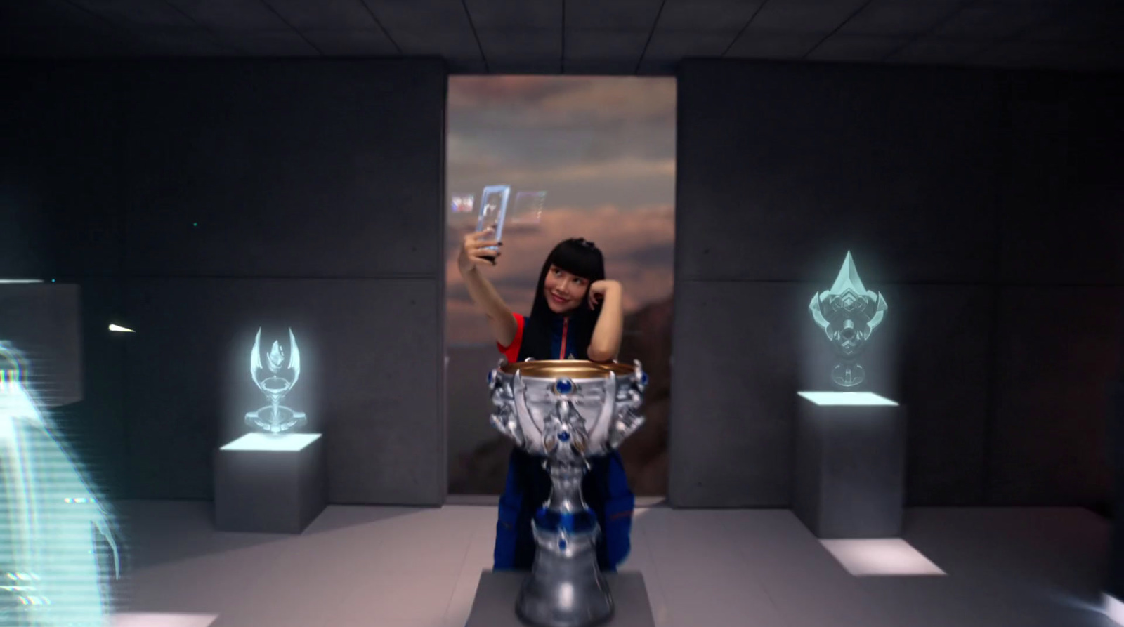 a woman holding a cell phone in front of a silver vase