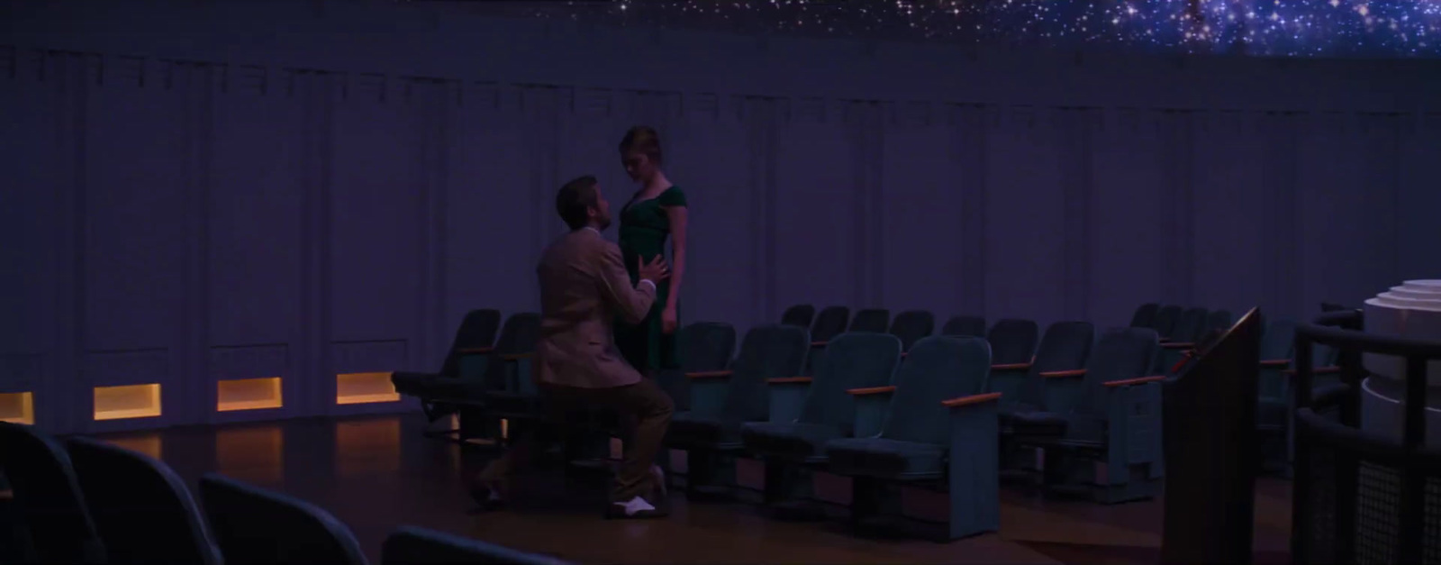 a man and a woman standing in front of a stage