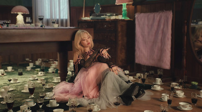 a woman sitting on the floor surrounded by tea cups