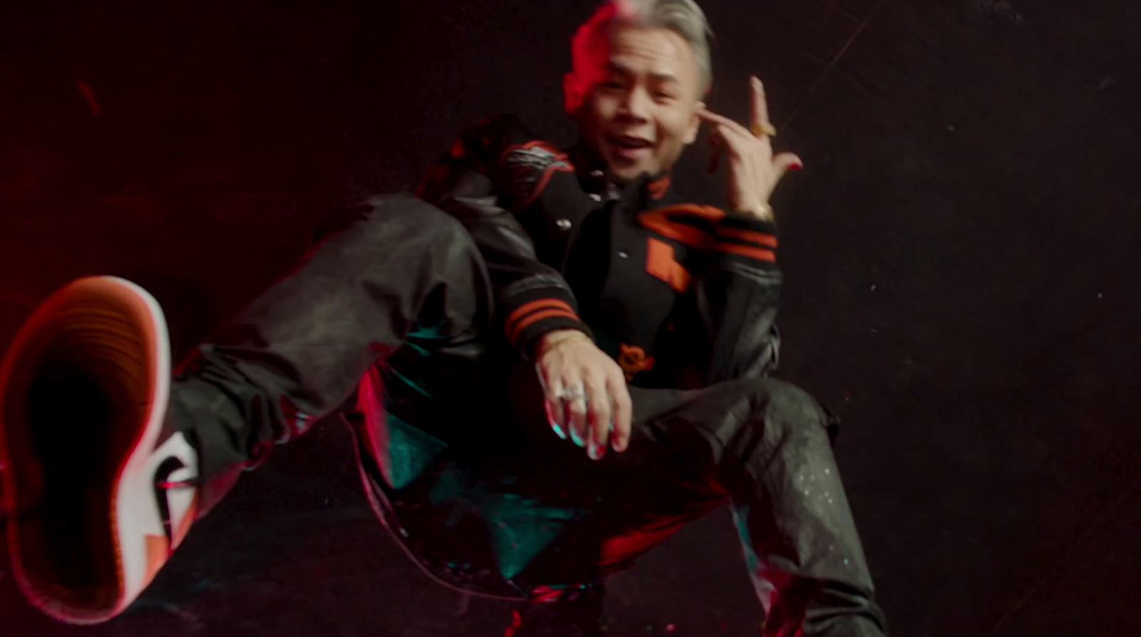 a man sitting on top of a chair making a peace sign