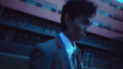 a man in a suit and tie standing in front of a building