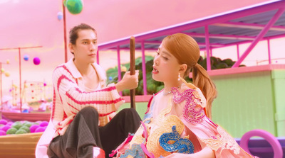 a woman sitting next to a man in a pink room