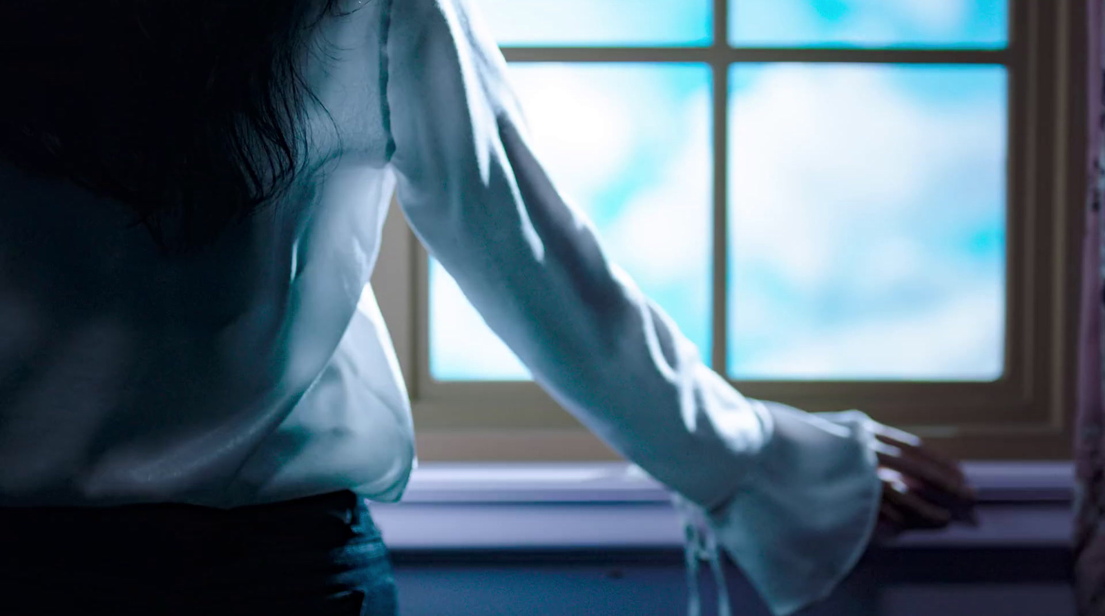 a woman standing in front of a window