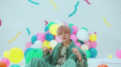 a boy sitting on the floor surrounded by balloons