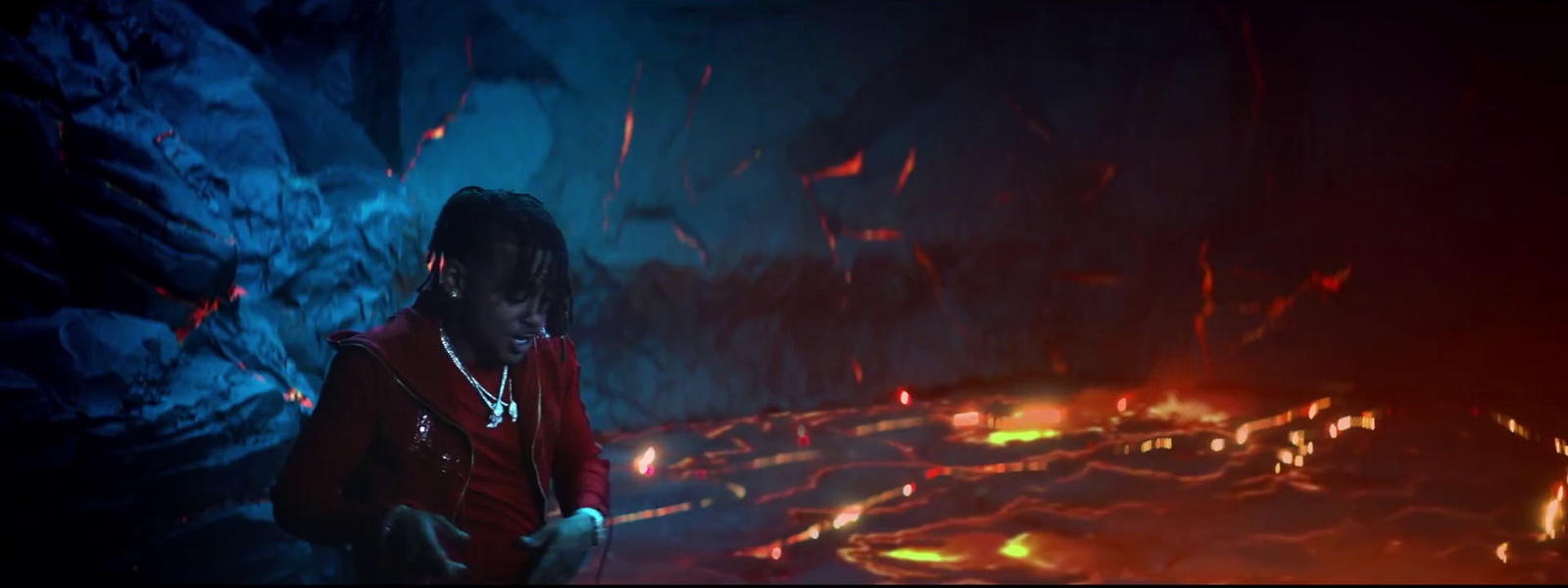 a man standing in front of a fire filled cave