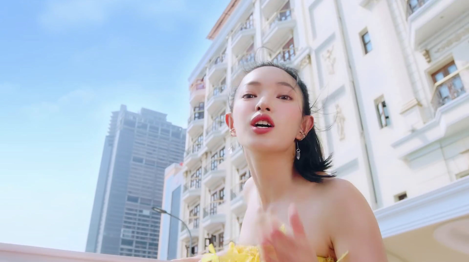 a woman in a yellow dress standing in front of a building