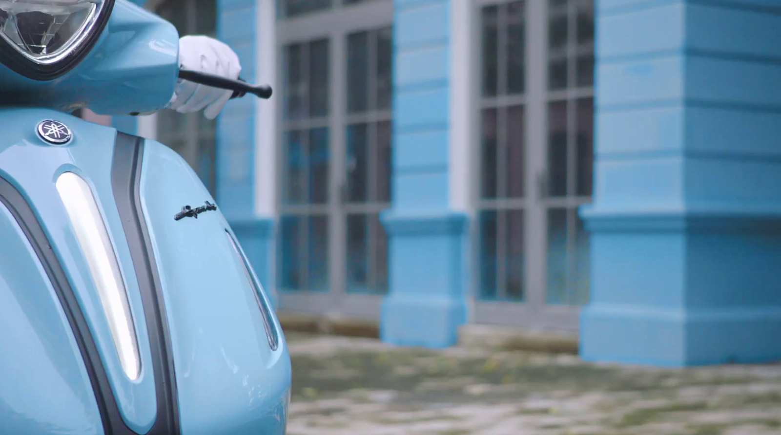 a blue scooter parked in front of a blue building