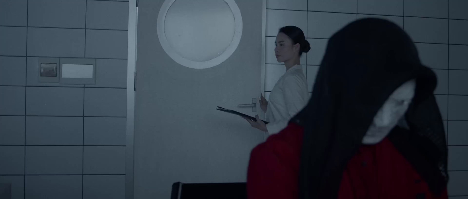 a woman standing in a bathroom next to a mirror