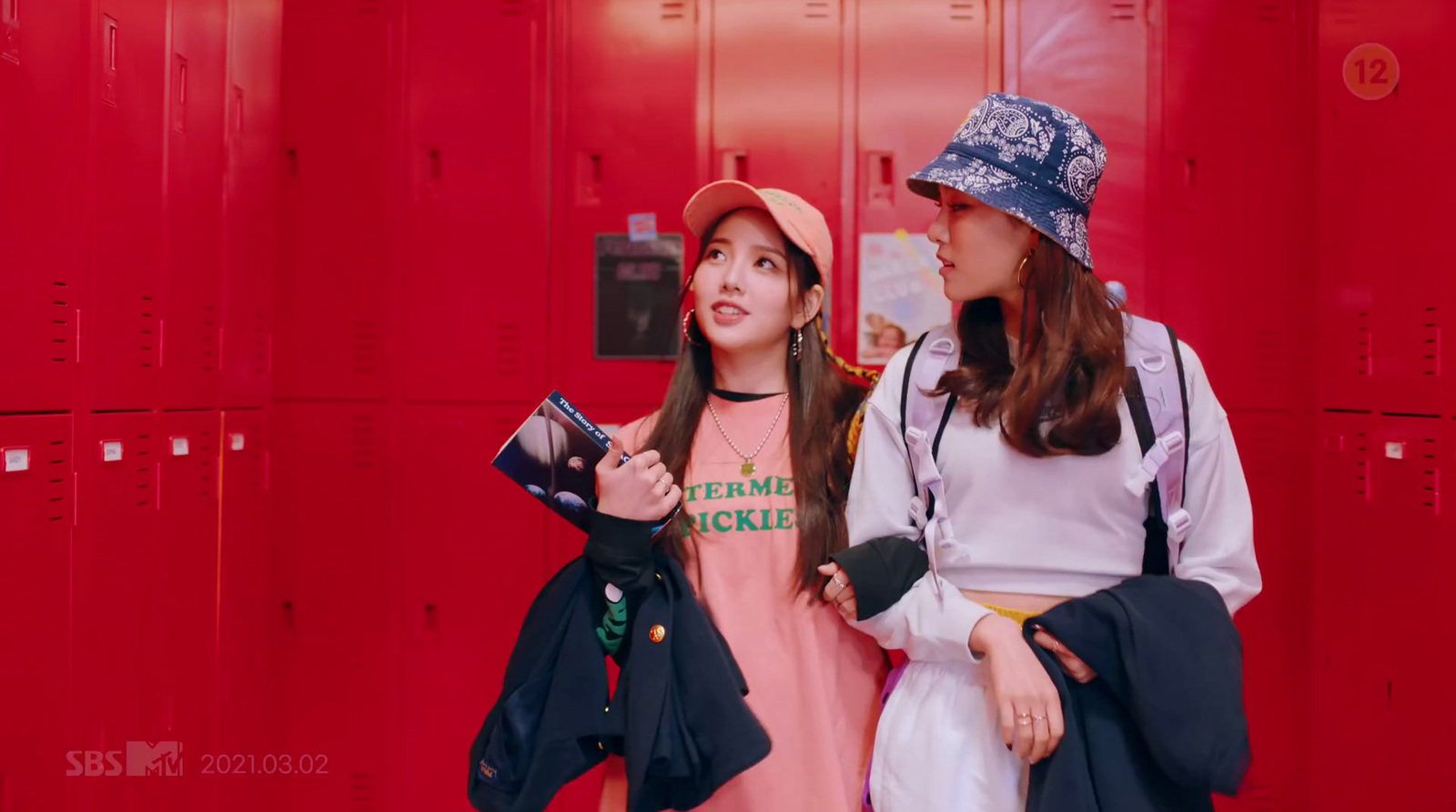 two young women standing in a locker room