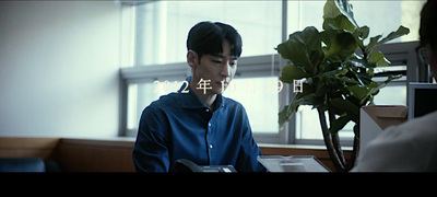 a man sitting at a desk with a plant in front of him