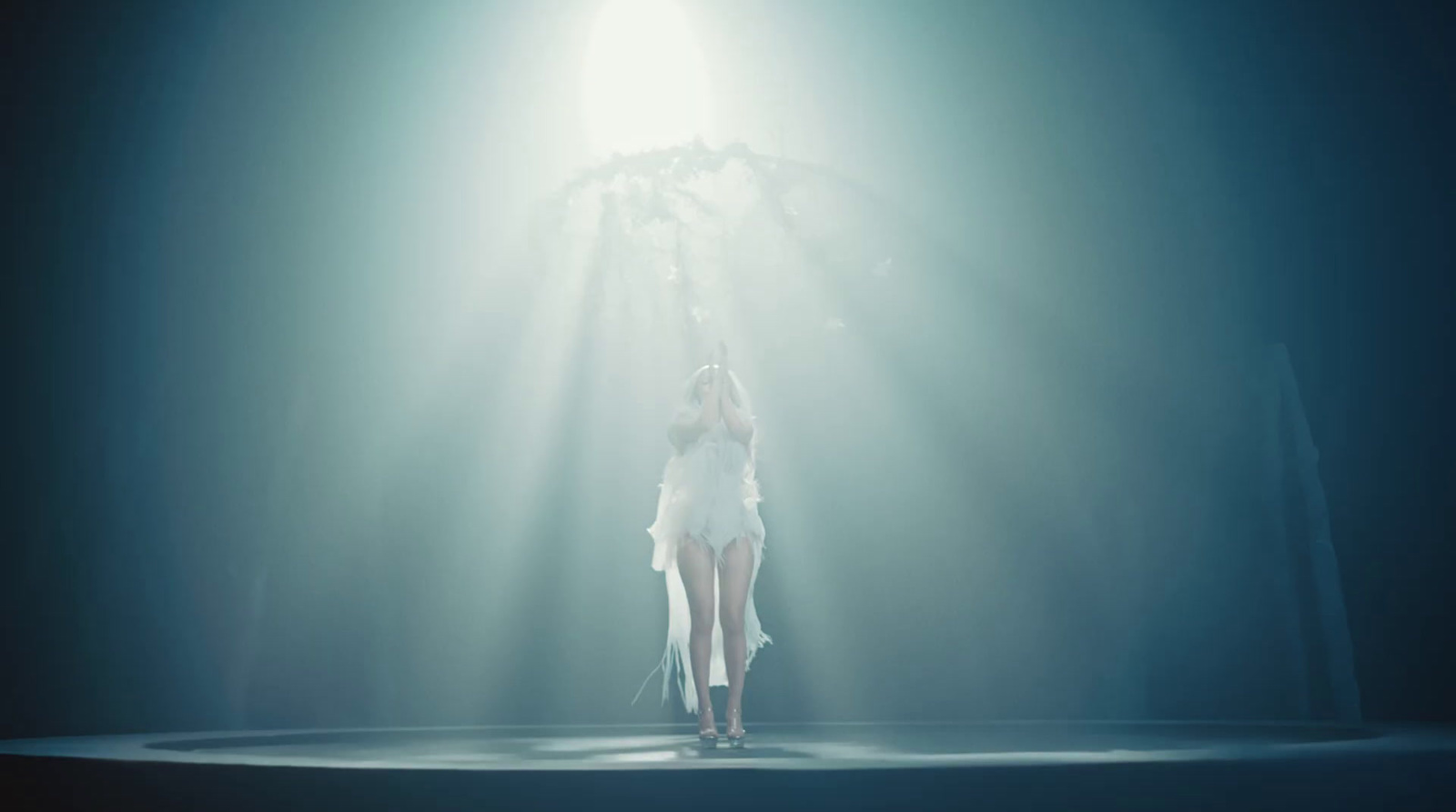 a woman in a white dress standing on a stage