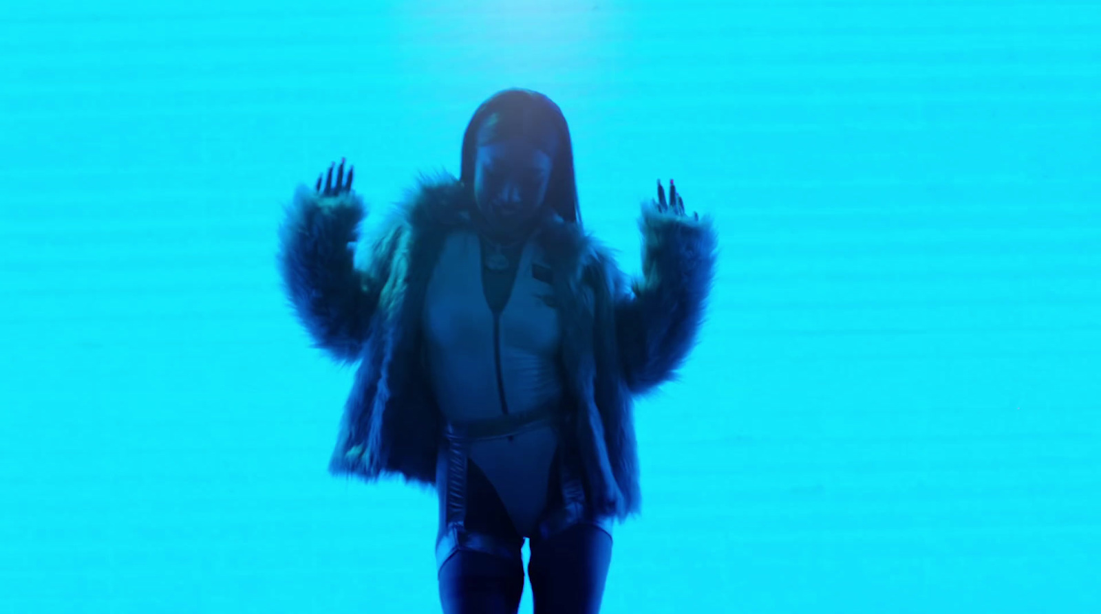 a woman in a black and white outfit standing in front of a blue background