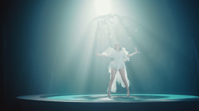 a woman in a white dress on a stage