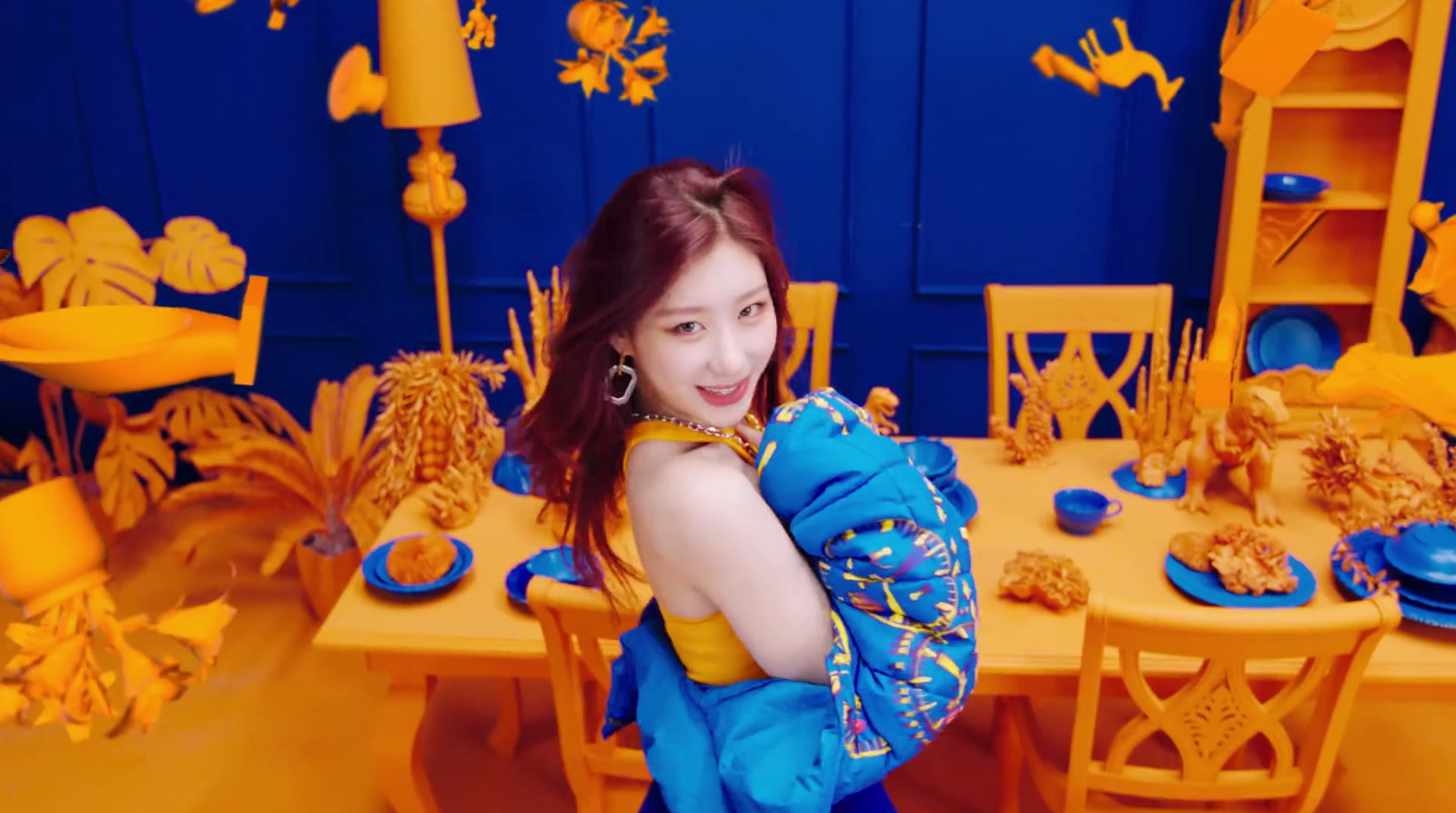 a woman standing in front of a table with blue and yellow decorations