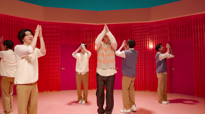 a group of people standing in front of a red wall