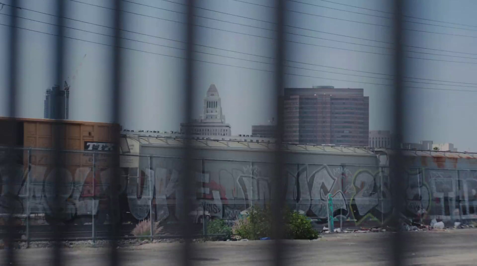 a view of a train station through a fence