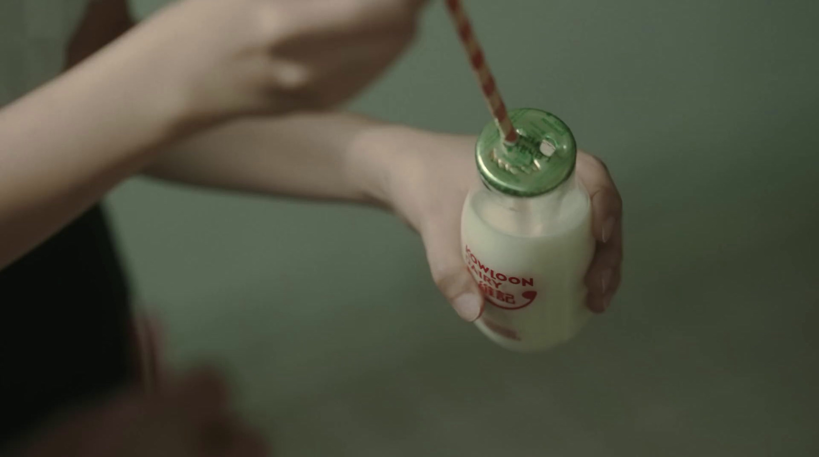 a person holding a bottle with a straw in it