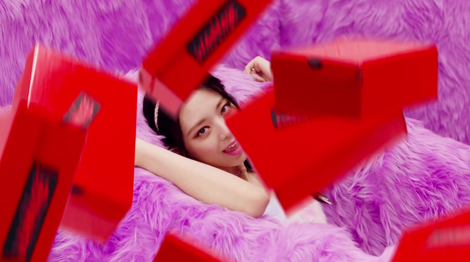 a woman laying on top of a purple fuzzy couch