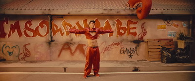 a man standing in front of a graffiti covered wall