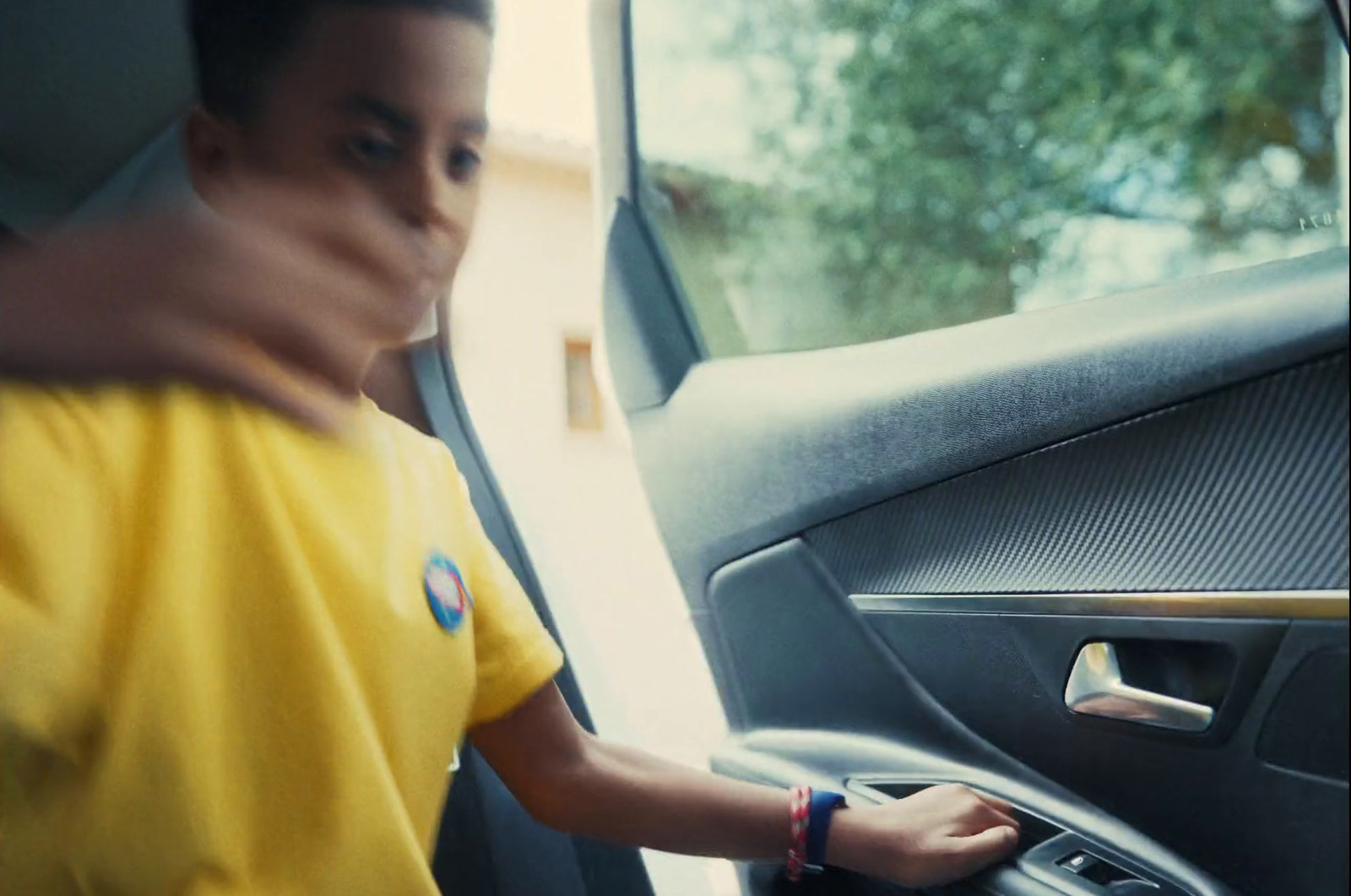 a man in a yellow shirt is opening the door of a truck