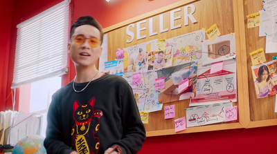 a man wearing sunglasses standing in front of a bulletin board