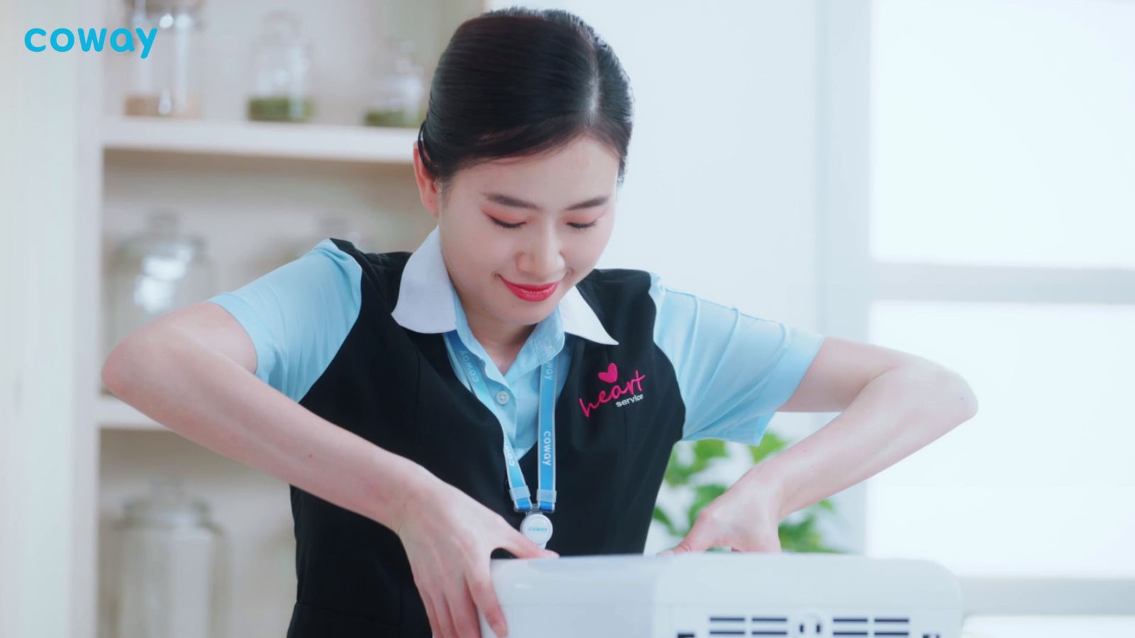 a woman in a blue shirt is putting something in a box