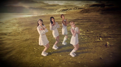 a group of young women standing on top of a grass covered field