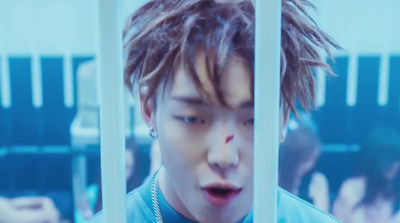 a young man is looking through the bars of a jail cell