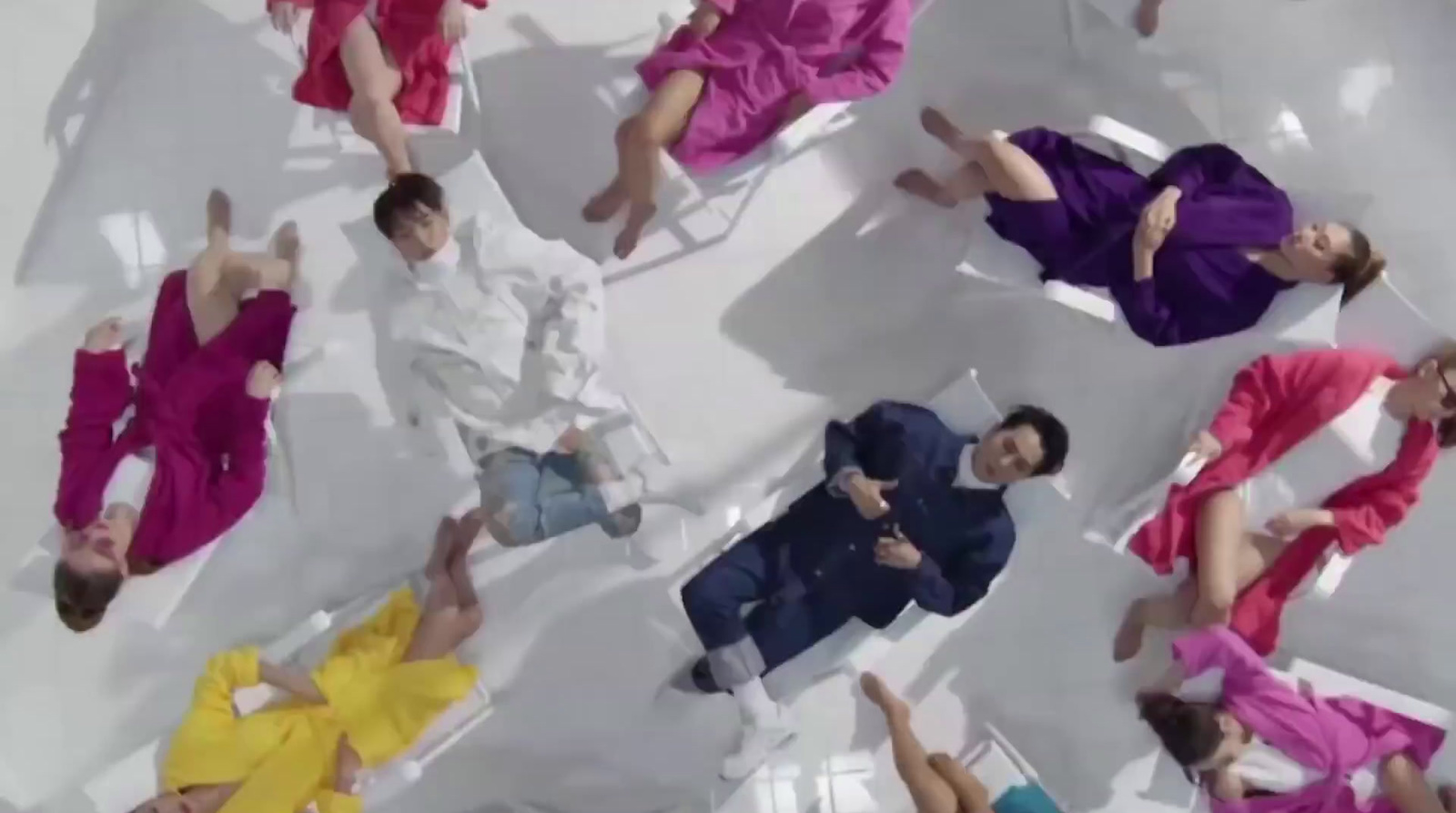 a group of people laying on top of a white floor