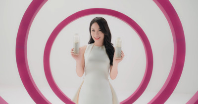 a woman in a white dress holding two glasses of milk