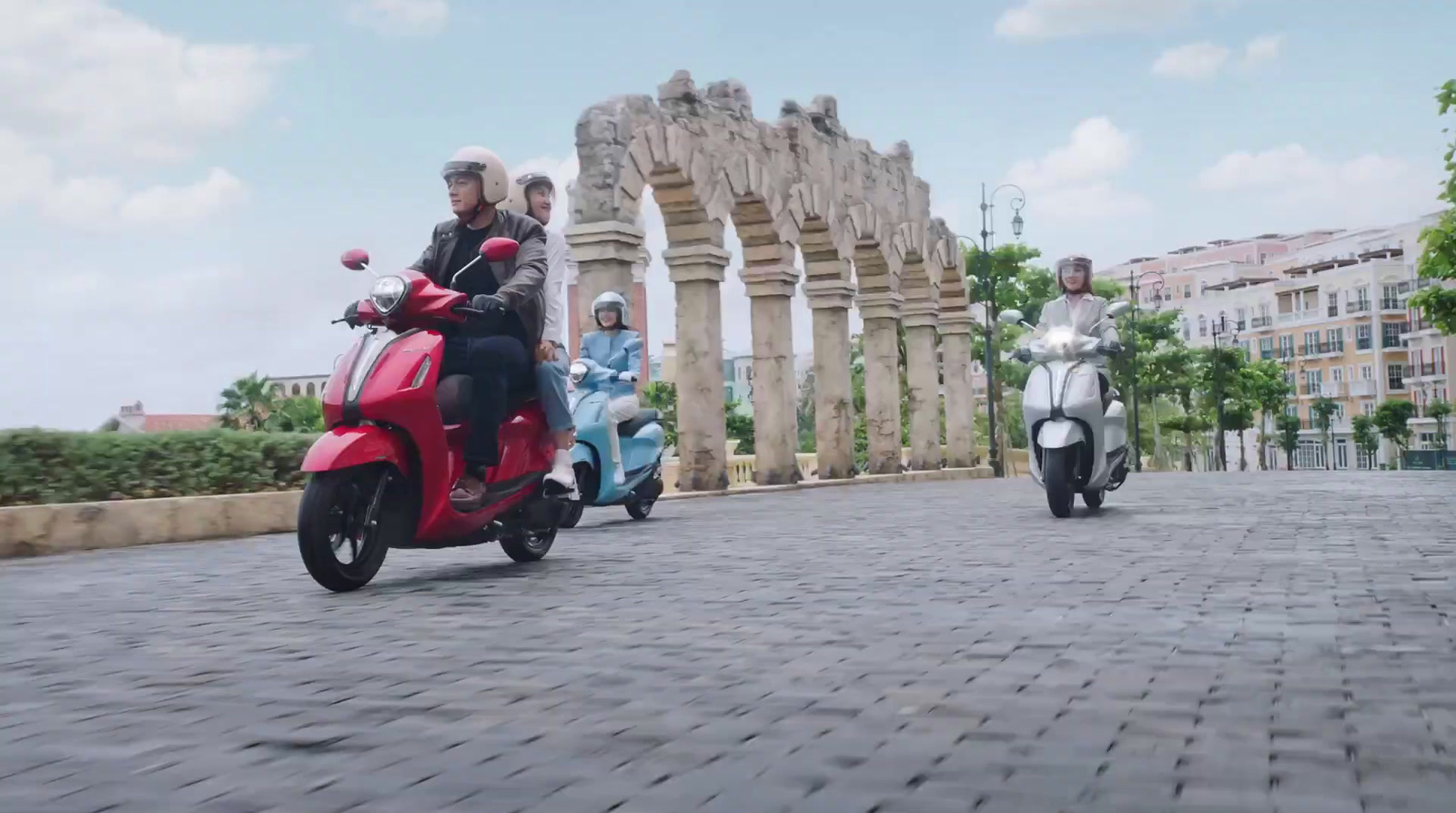 a group of people riding scooters down a street