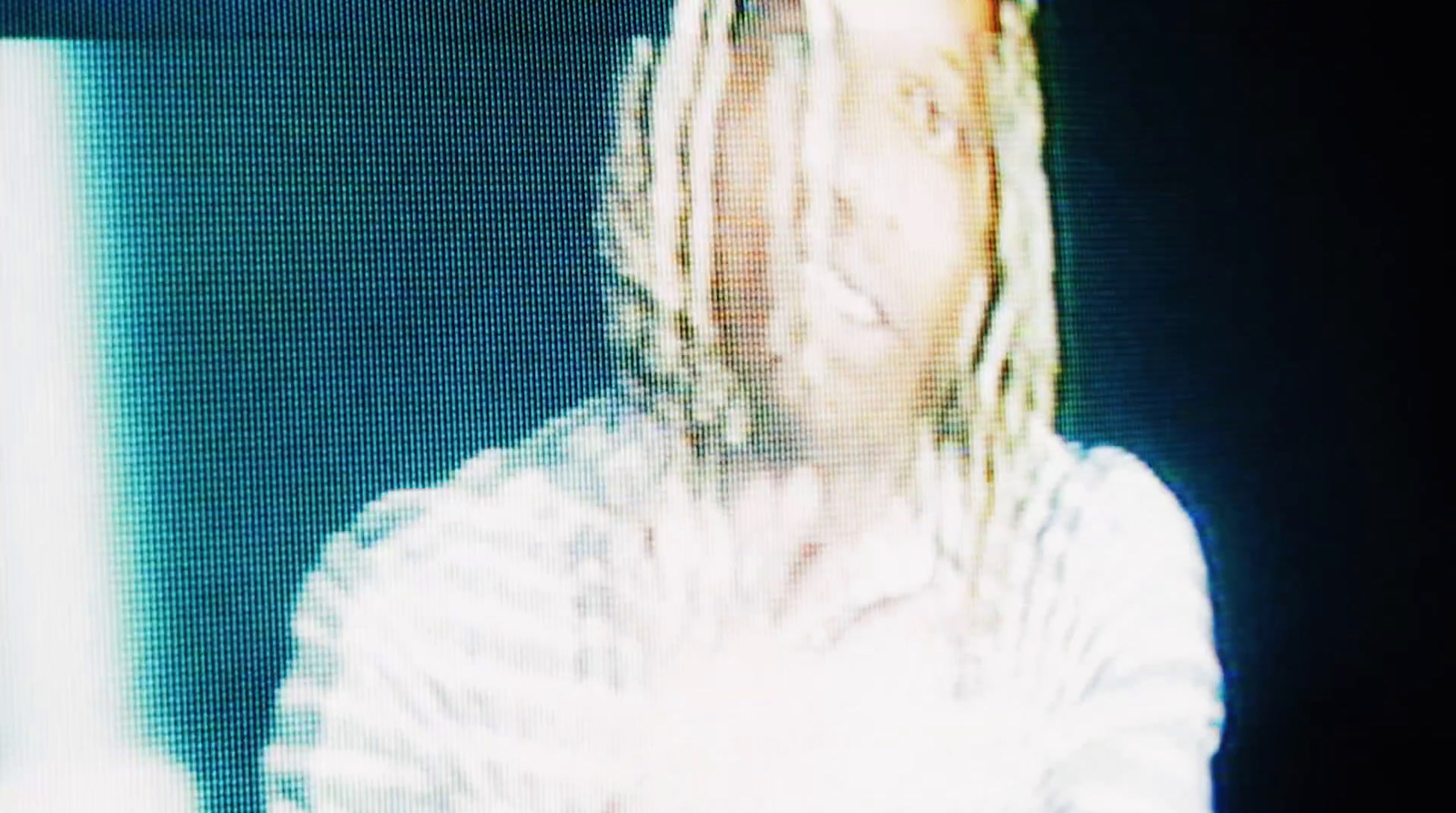 a blurry photo of a person with dreadlocks