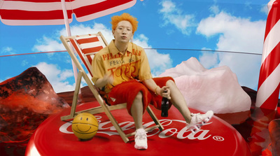 a man sitting on top of a coca cola chair