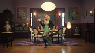 a woman in a green dress dancing in a room