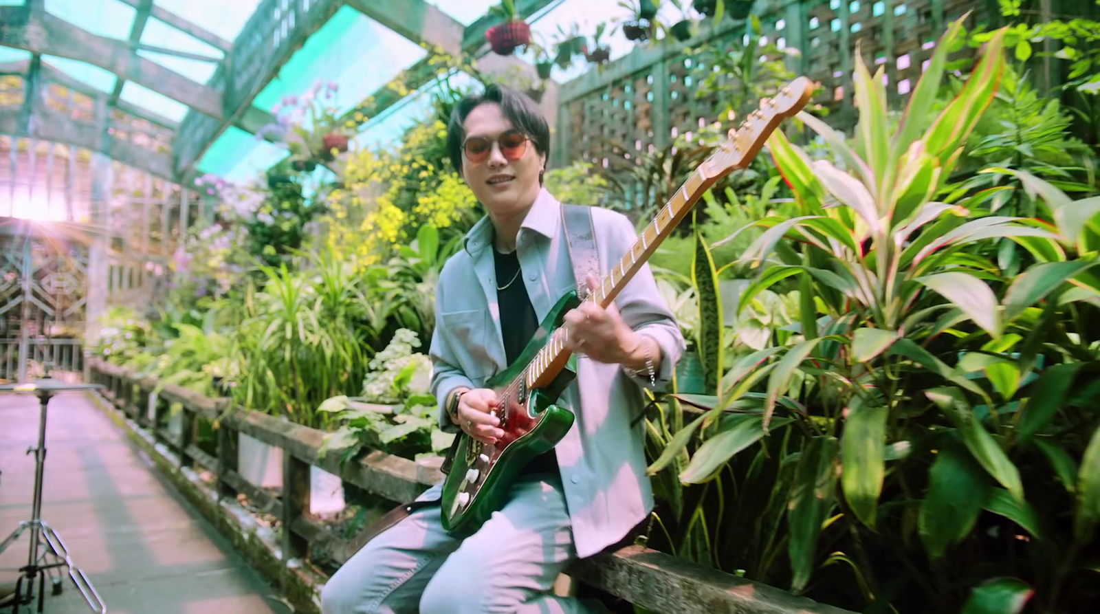 a man sitting on a bench holding a guitar