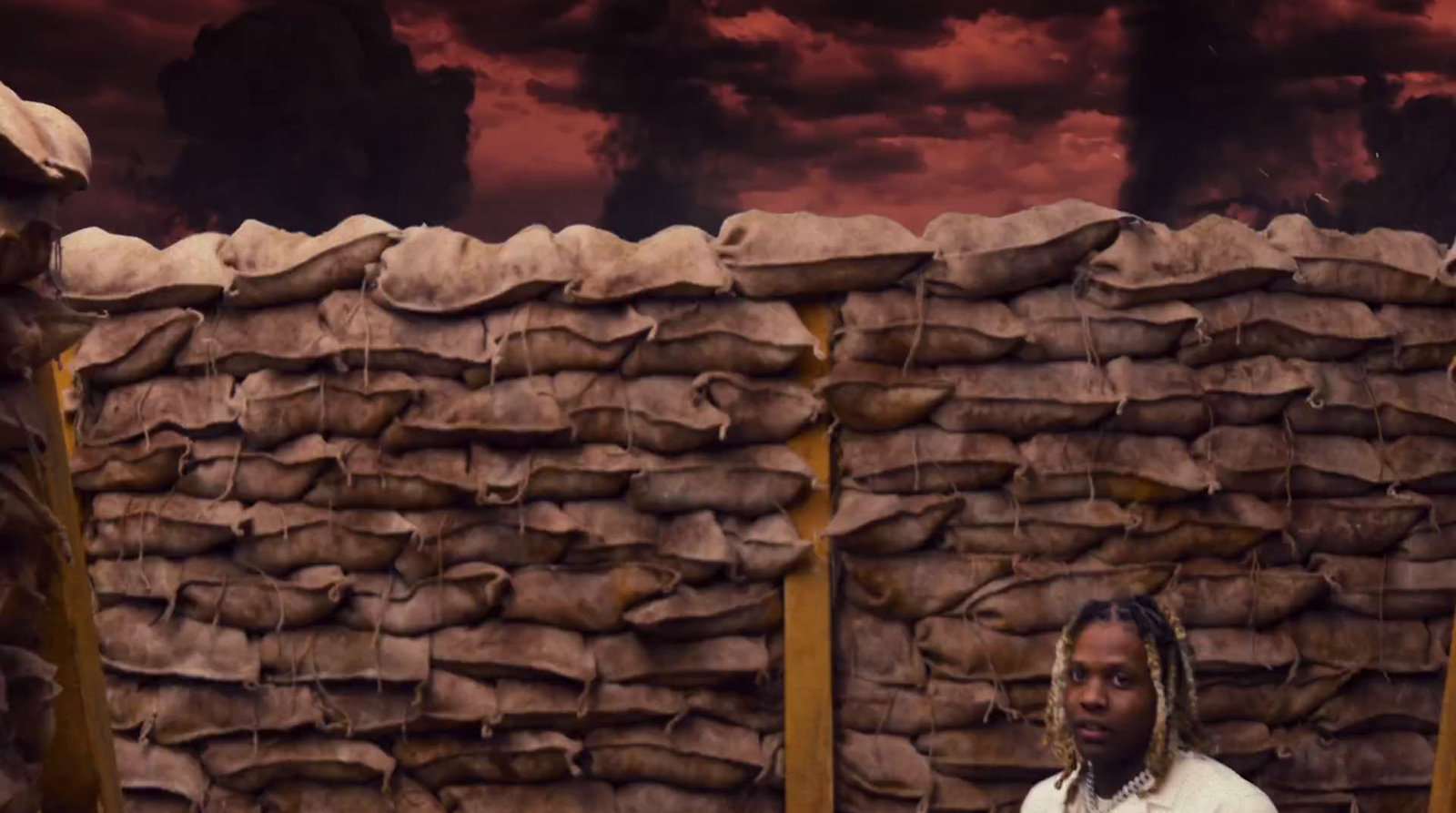 a man standing in front of a pile of sand bags