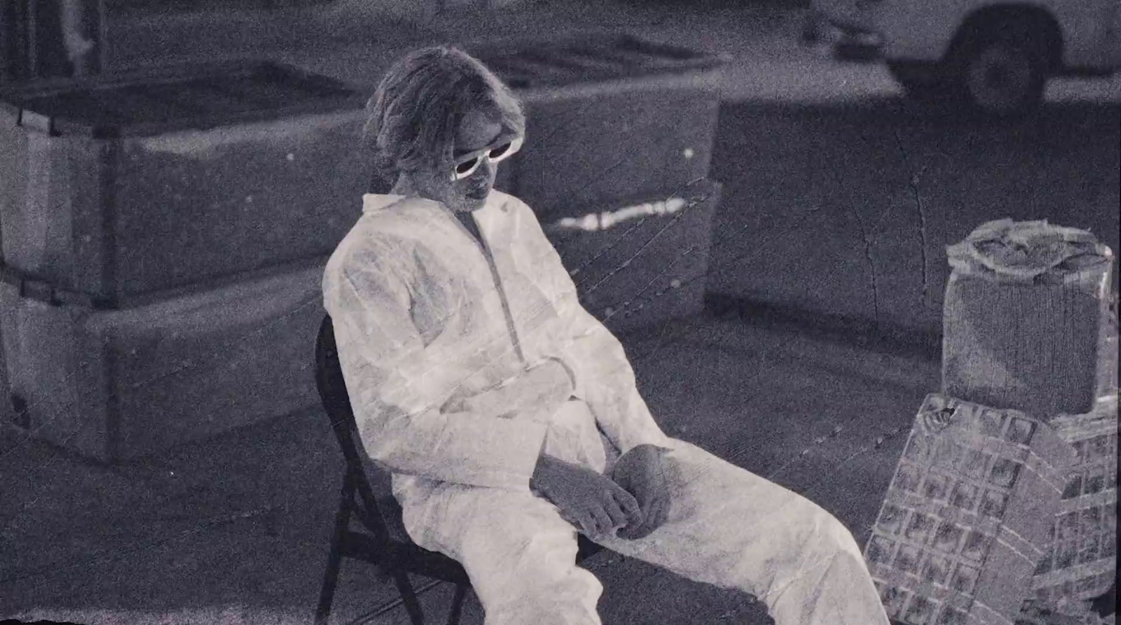 a man sitting on top of a chair next to a pile of boxes