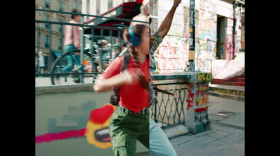 a man in red shirt doing a trick on a skateboard