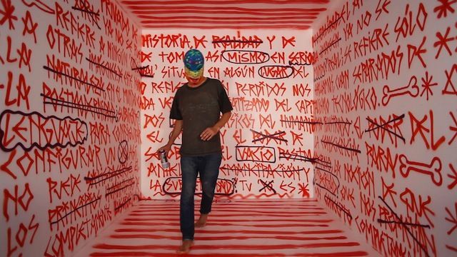 a man standing in a room covered in graffiti