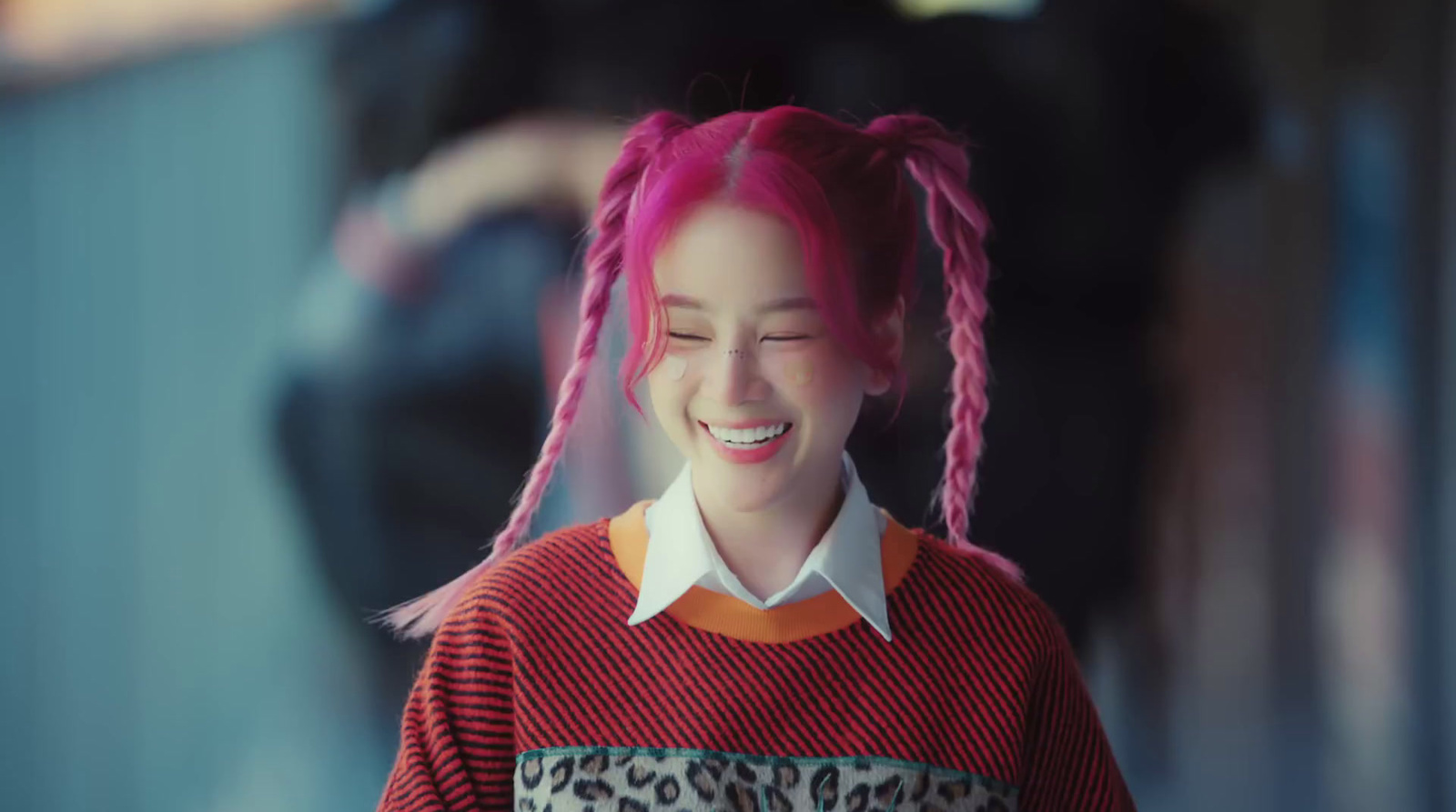 a woman with pink hair and a red sweater