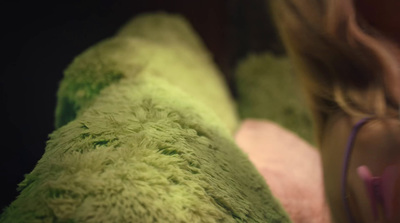 a woman laying on top of a green pillow