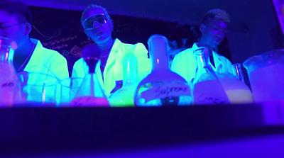 a group of men in lab coats standing in front of bottles