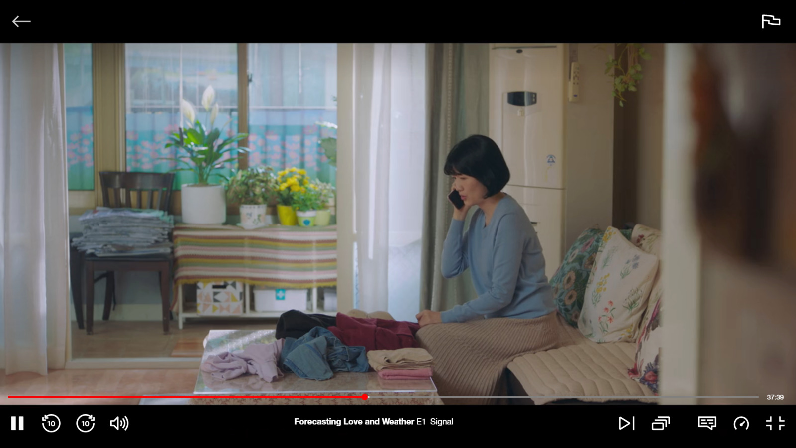 a woman sitting on a couch talking on a cell phone