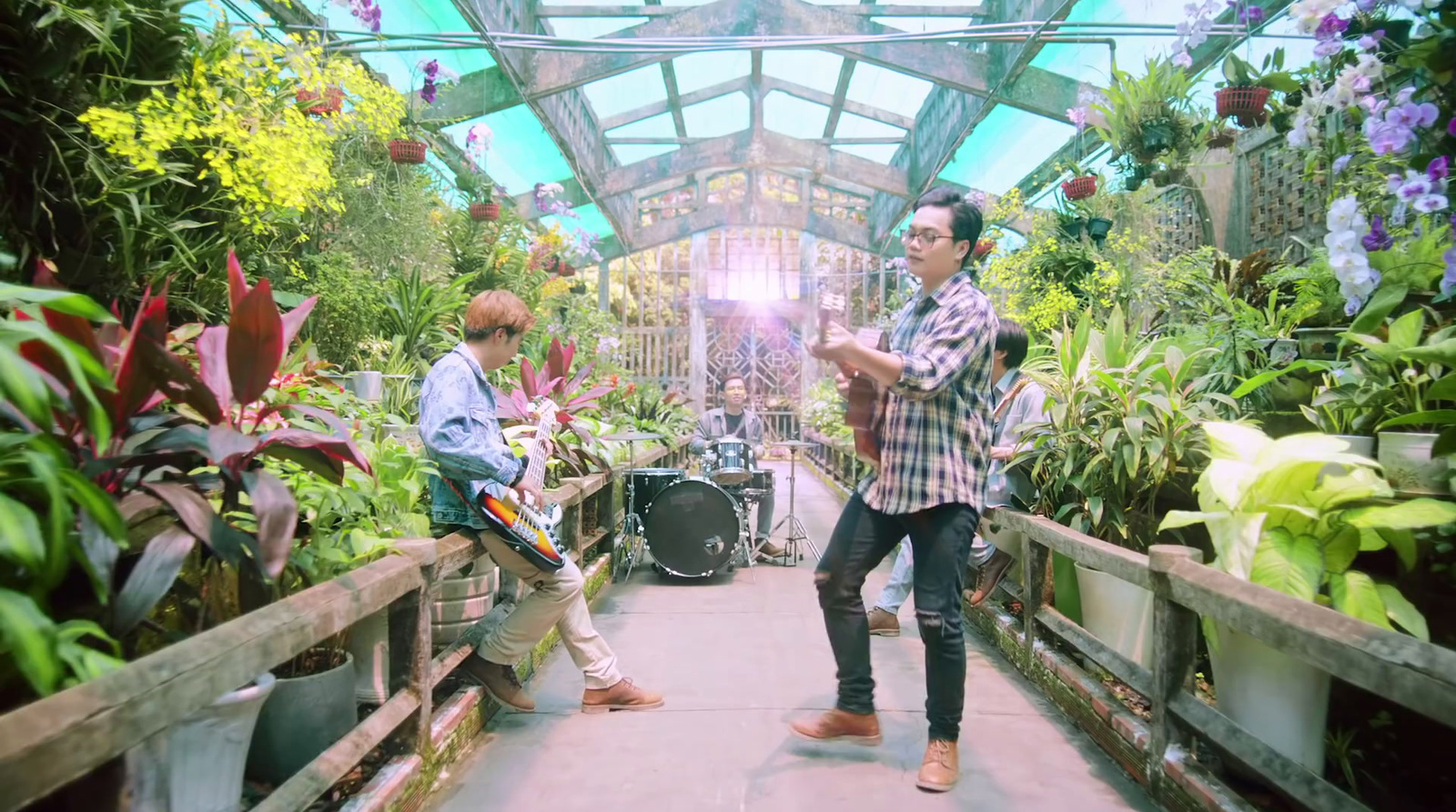 a couple of men standing next to each other in a greenhouse